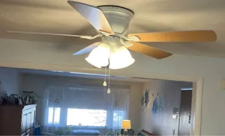 Modern three-light ceiling fan with frosted glass installed in a residential room.