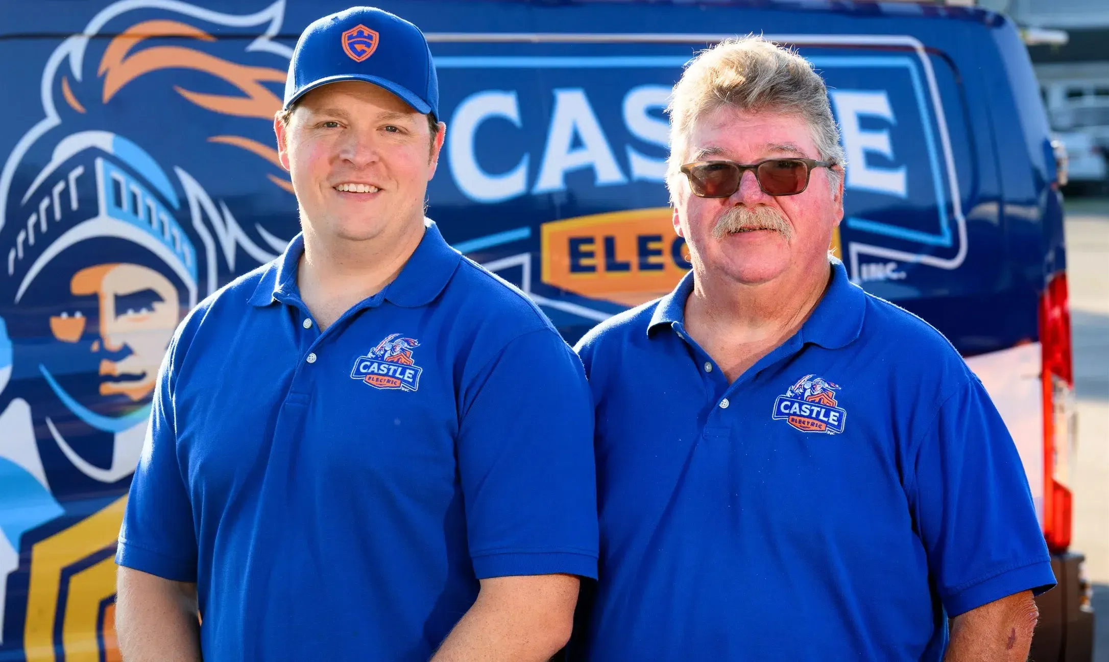 Castle Electric Inc. owners standing in front of branded service van serving Newton and Norwood MA
