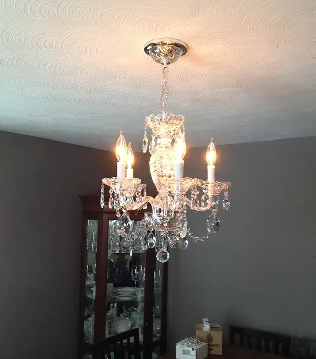 Elegant crystal chandelier installation in an Eastern Massachusetts dining room by Castle Electric Inc.