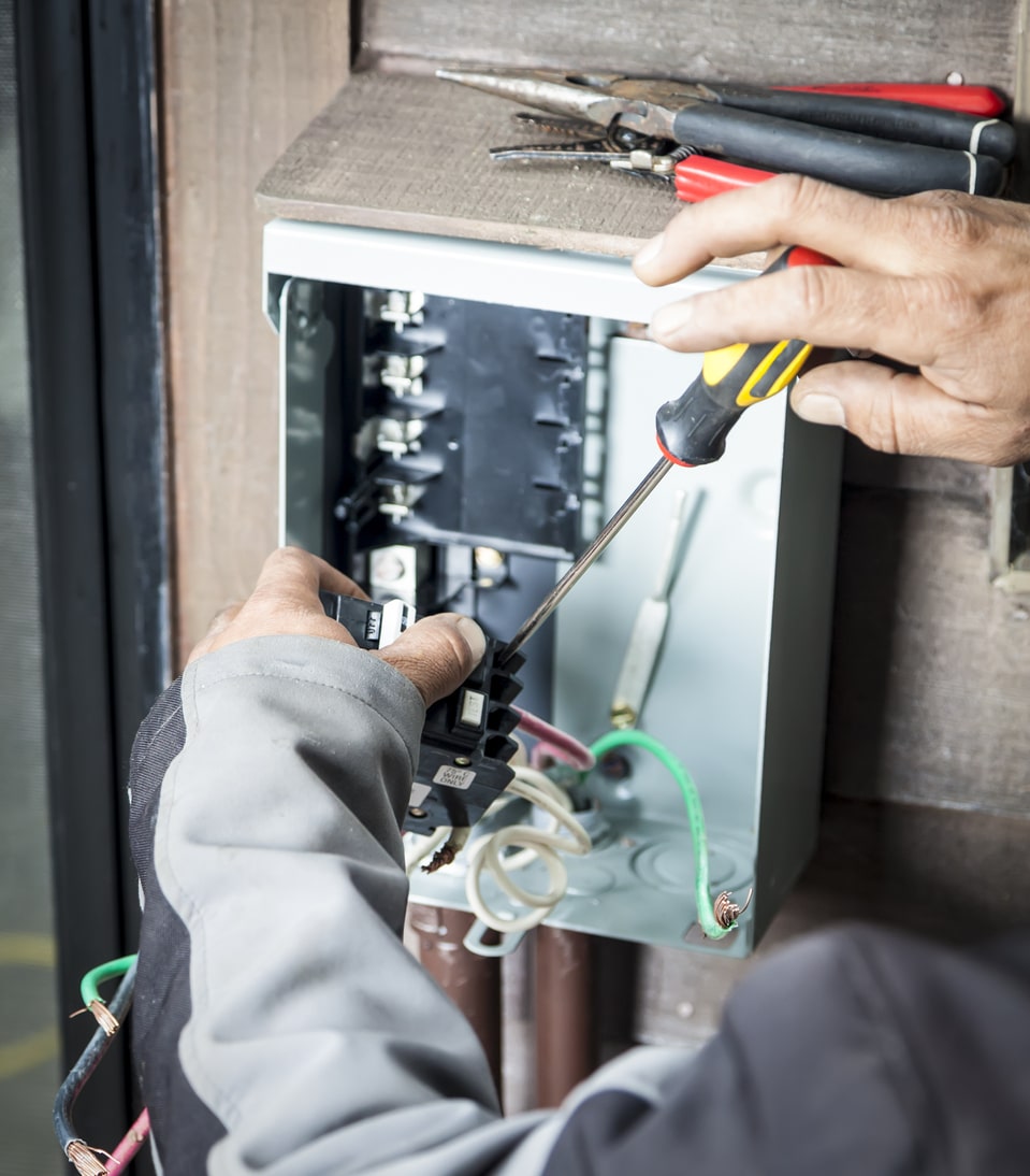 Electrician installing whole house surge protector in a home