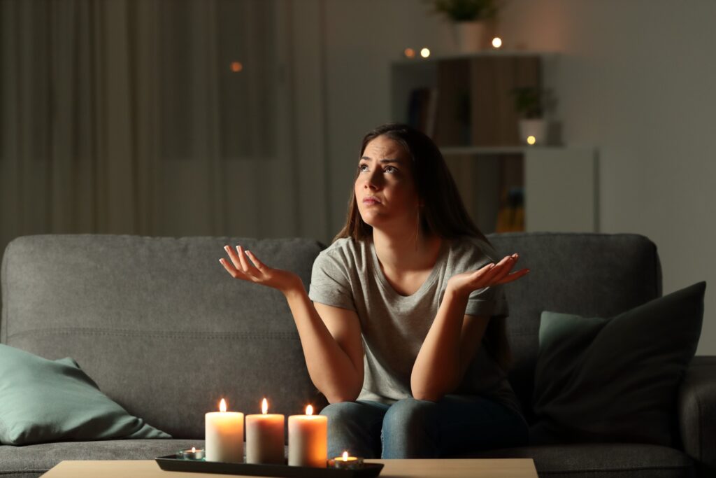 woman sitting in the living room with candles because the power went out